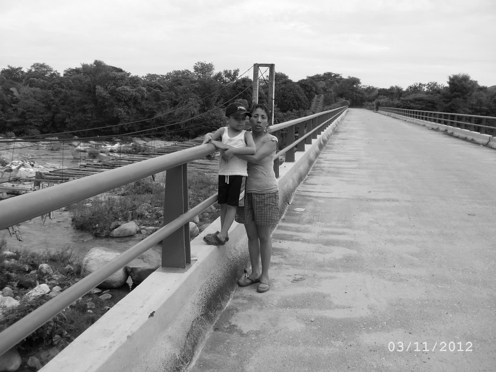 Johan as a child with his mother on the bridge at El Coquillo, the old wooden suspension bridge visible below. 2012.