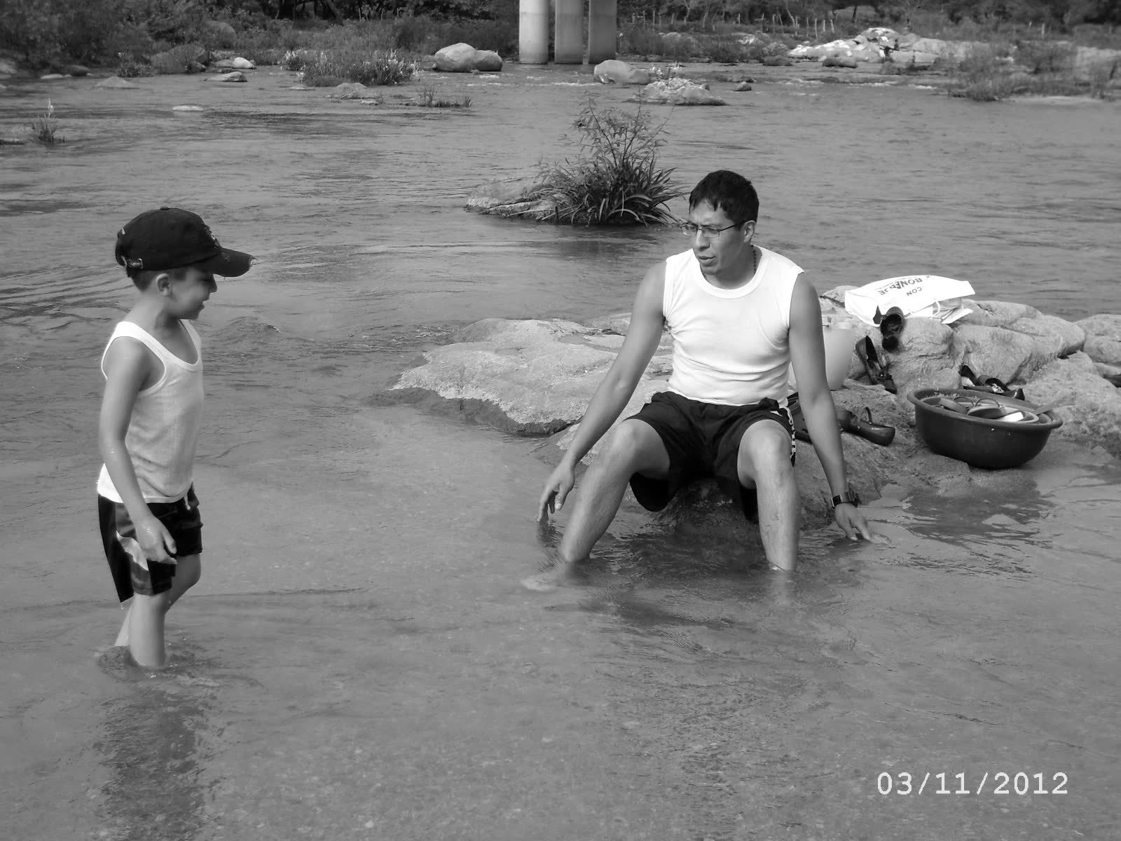 Johan and a relative in the shallows of the river at El Coquillo, laundry drying on the rocks behind. 2012.